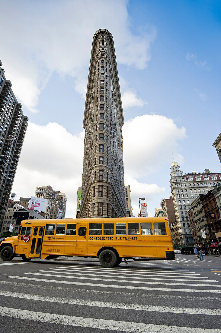 Flatiron Building and Broadway with schoolbus, Manhattan, New York, USA