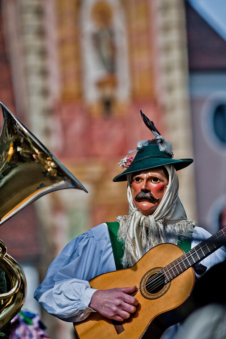 Disguised person playing the guitar at carnival, Mittenwald, Bavaria, Germany, Europe