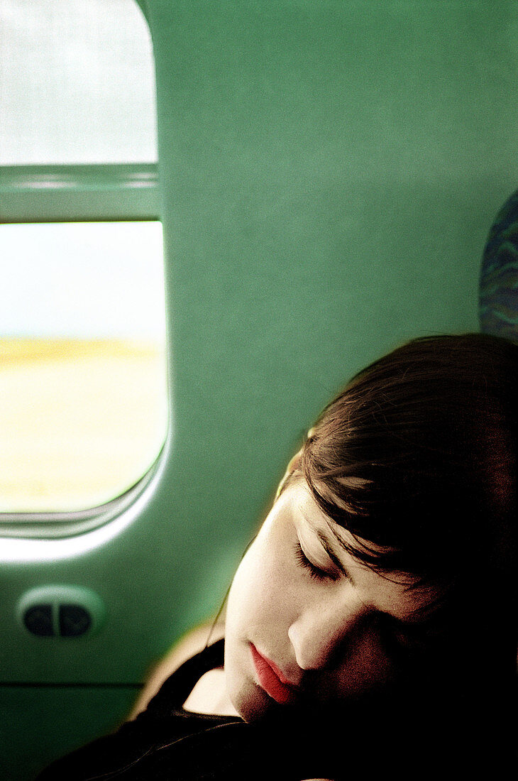 Frau schläft in Zug