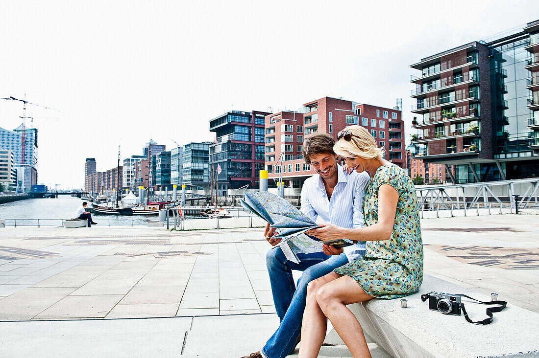 Paar mit einem Stadtplan an den Magellan-Terrassen, HafenCity, Hamburg, Deutschland