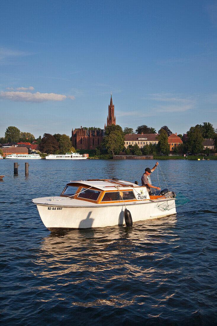 Fischer im Motorboot, Blick über den Fleesensee zum Kloster Malchow, Müritz-Elde-Wasserstrasse, Mecklenburgische Seenplatte, Mecklenburg-Vorpommern, Deutschland, Europa