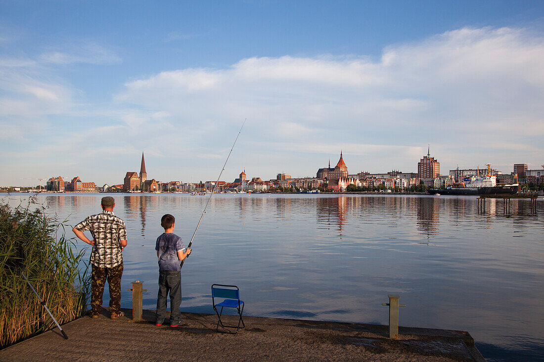 Angler am Ufer, Blick über die Warnow zur Altstadt mit Marienkirche, Rostock, Ostsee, Mecklenburg-Vorpommern, Deutschland, Europa