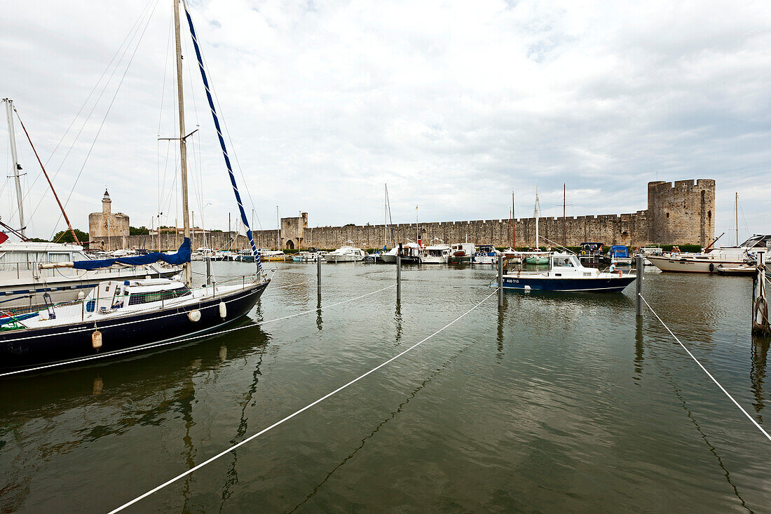 Sailing boats in marina, city wall in background, Aigues-Mortes, Gard, Languedoc-Roussillon, France