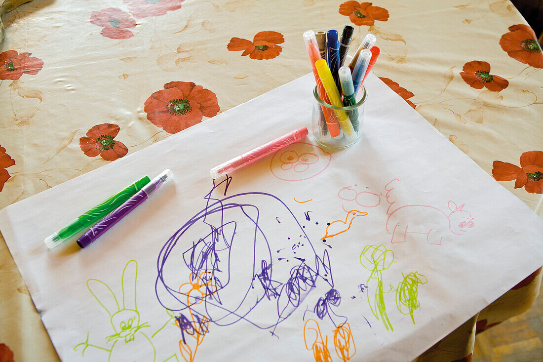 Child's drawing and color pens on table