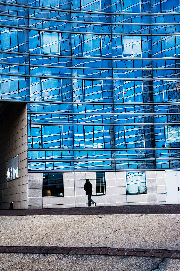 Person walking by modern building