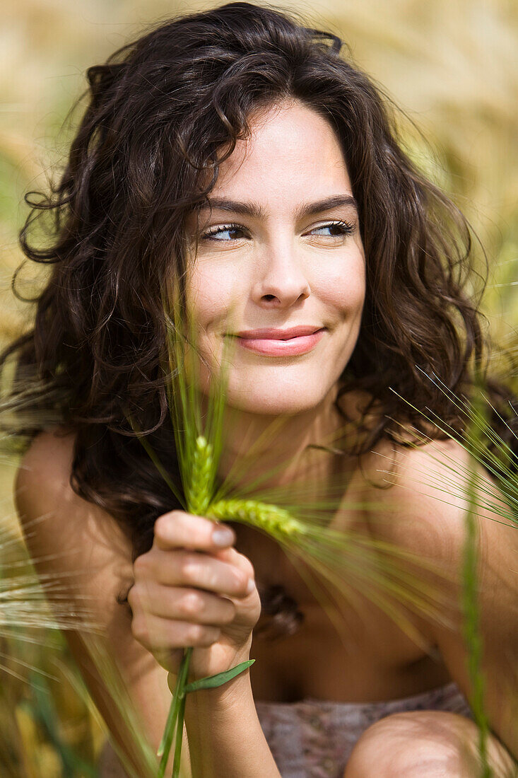 Young smiling woman holding wheat
