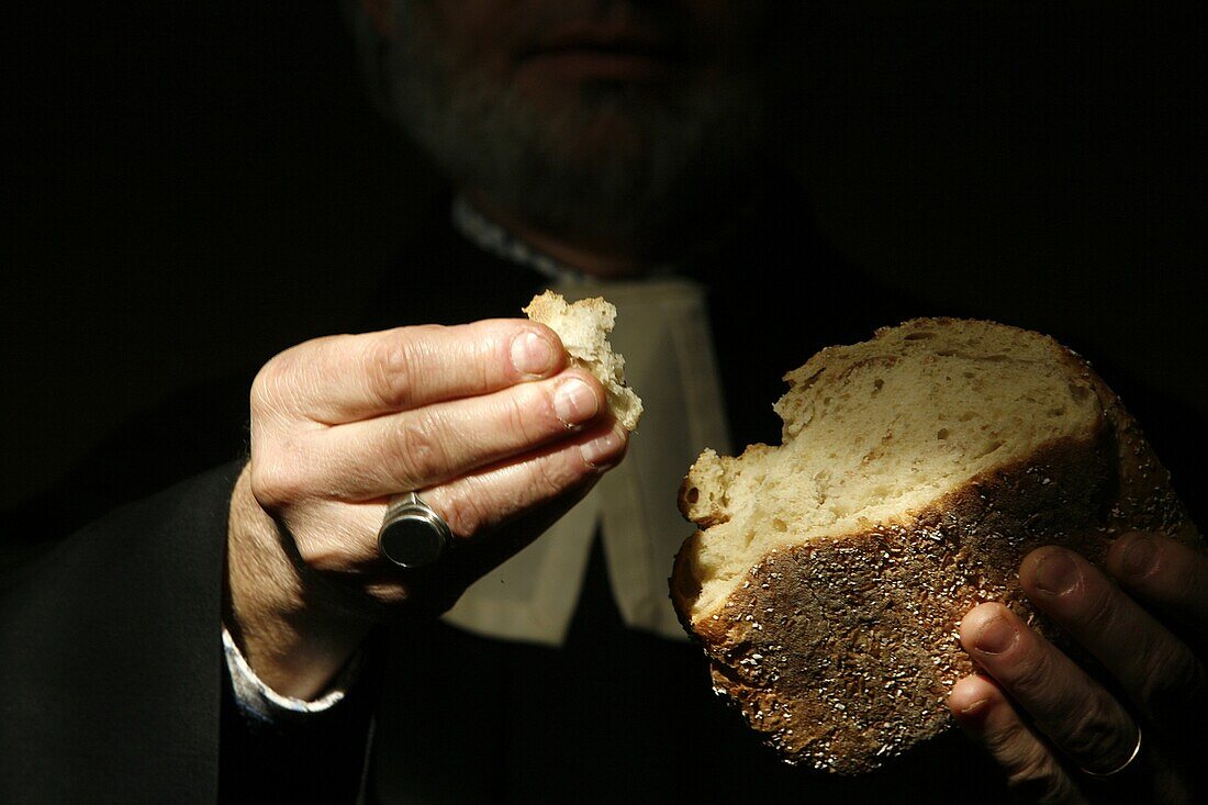 Suisse, Genève, Protestant minister holding communion bread