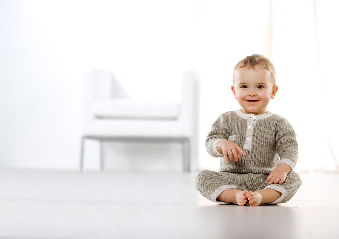 Smiling baby boy sitting on floor
