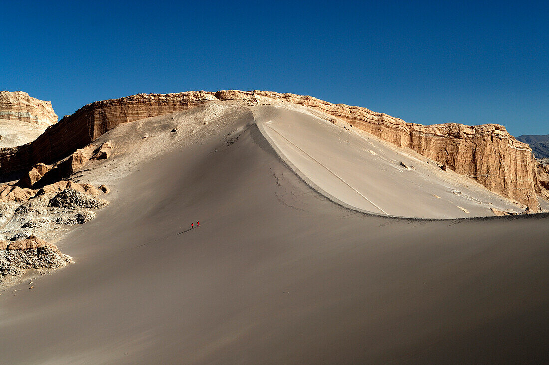 Chile, Valle de la Luna, dune against a salt cliff, two persons