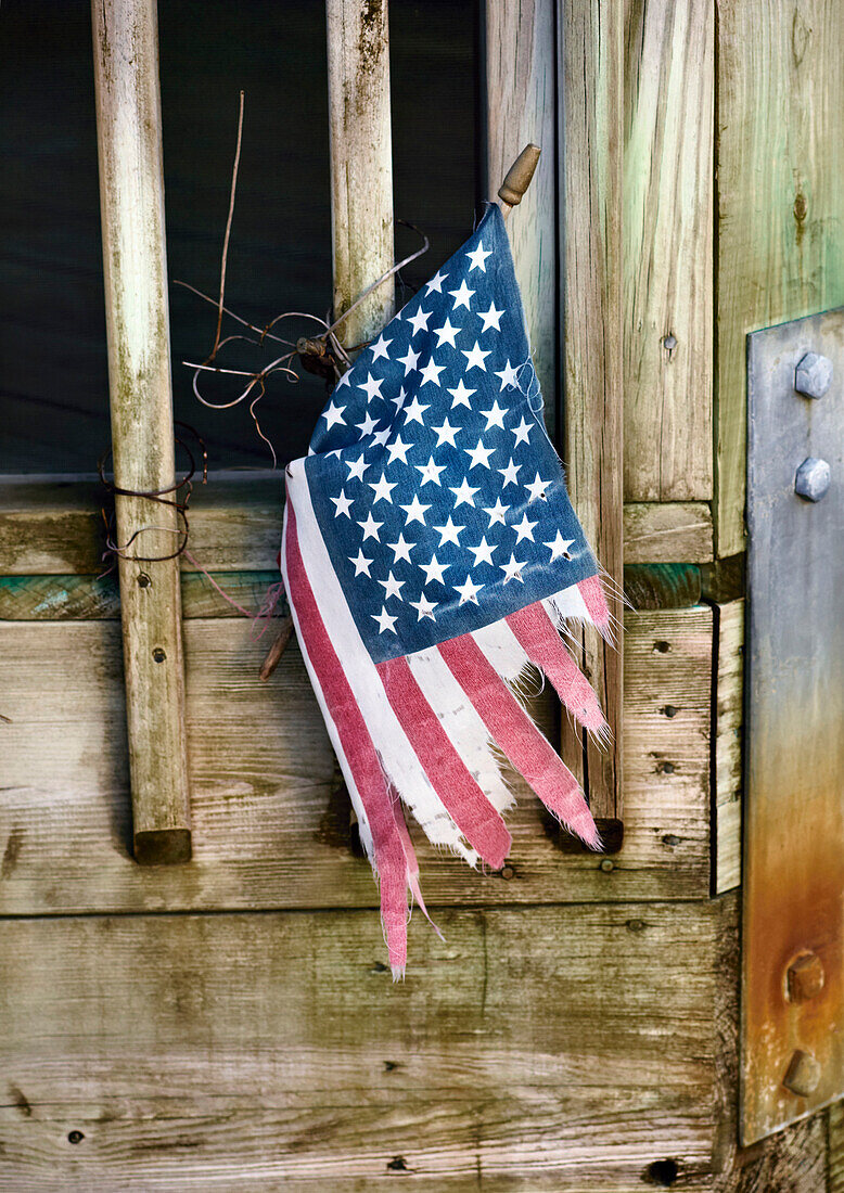 Tattered American Flag Tied to Weathered Door