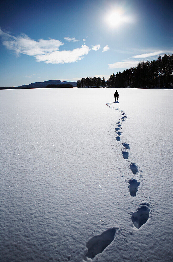 Woman and Footprints in Snow on Frozen Lake, Halsingland, Sweden