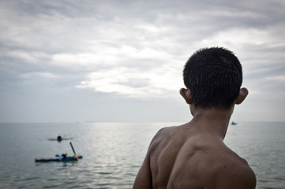 Boy Looking at Fisherman at Sea, Thailand