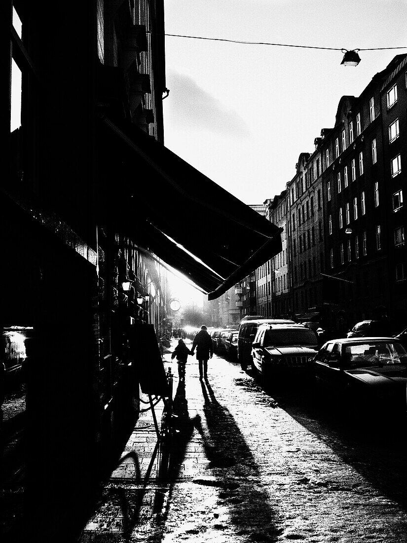 Adult and Child Walking Down Urban Street, Stockholm, Sweden