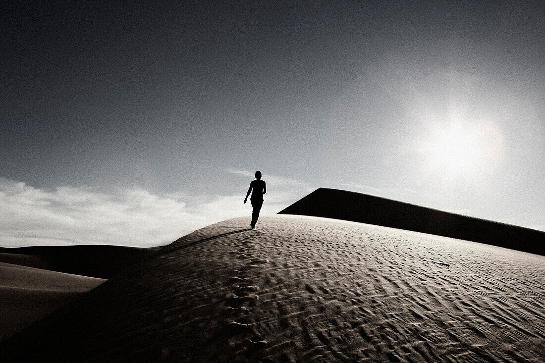 Woman Walking on Desert Sand Dune, Rear View, California, USA