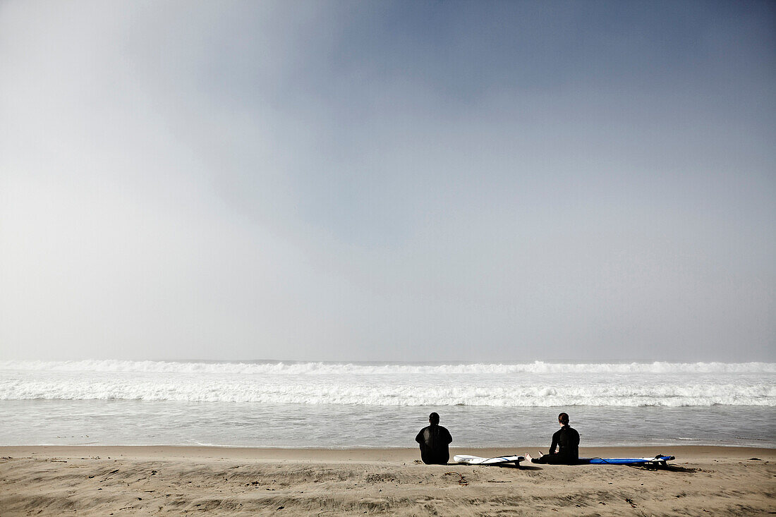 Two Surfers Sitting on Beach, San Diego, California, USA
