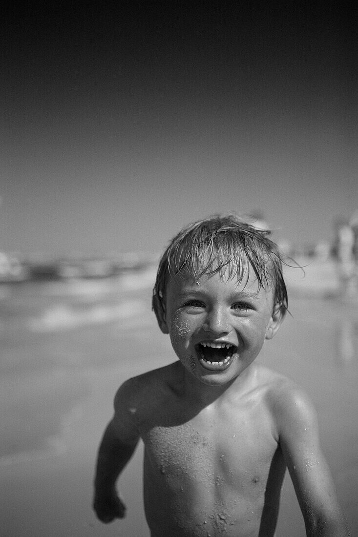 Smiling Blonde Boy on Beach