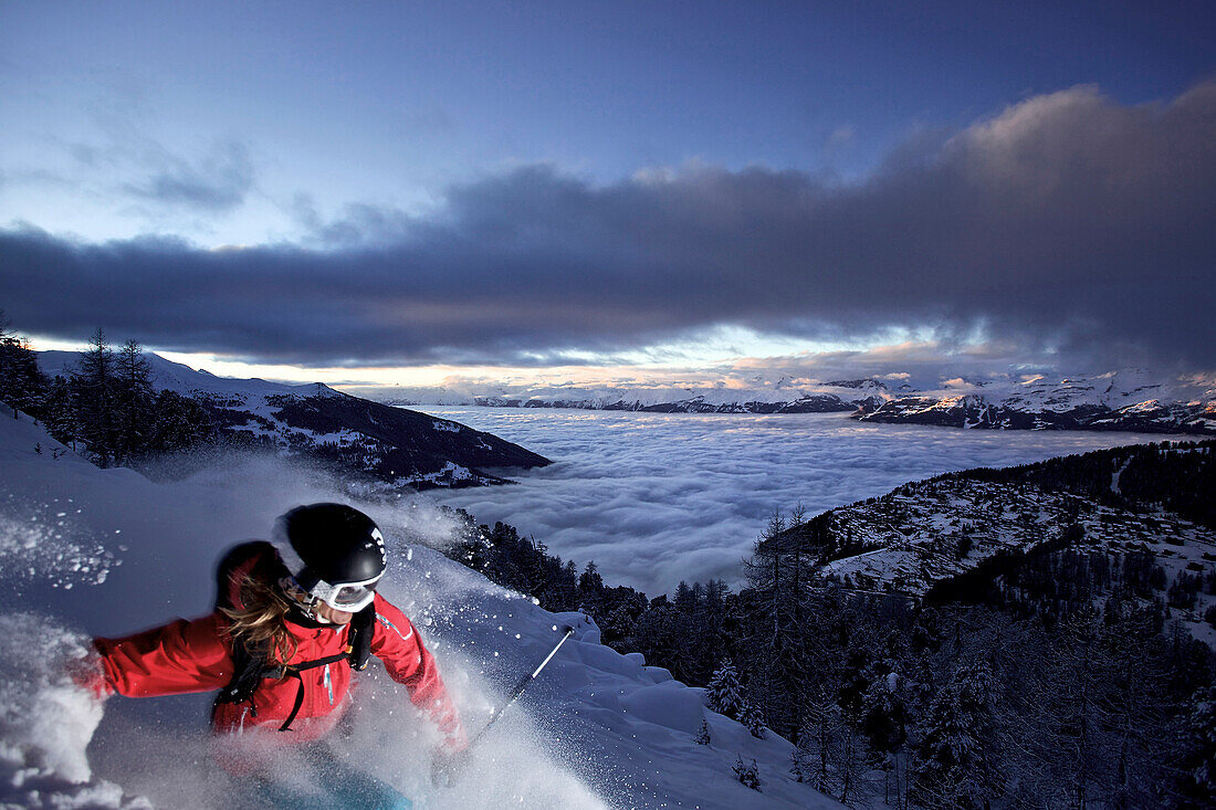 Female skier in deep snow at twilight, Chandolin, Anniviers, Valais, Switzerland