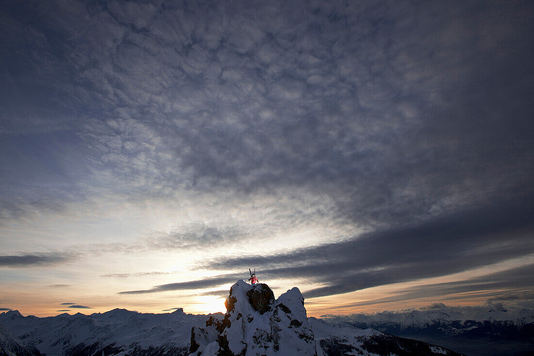 Female skier standing on a mountain top in twilight, Chandolin, Anniviers, Valais, Switzerland