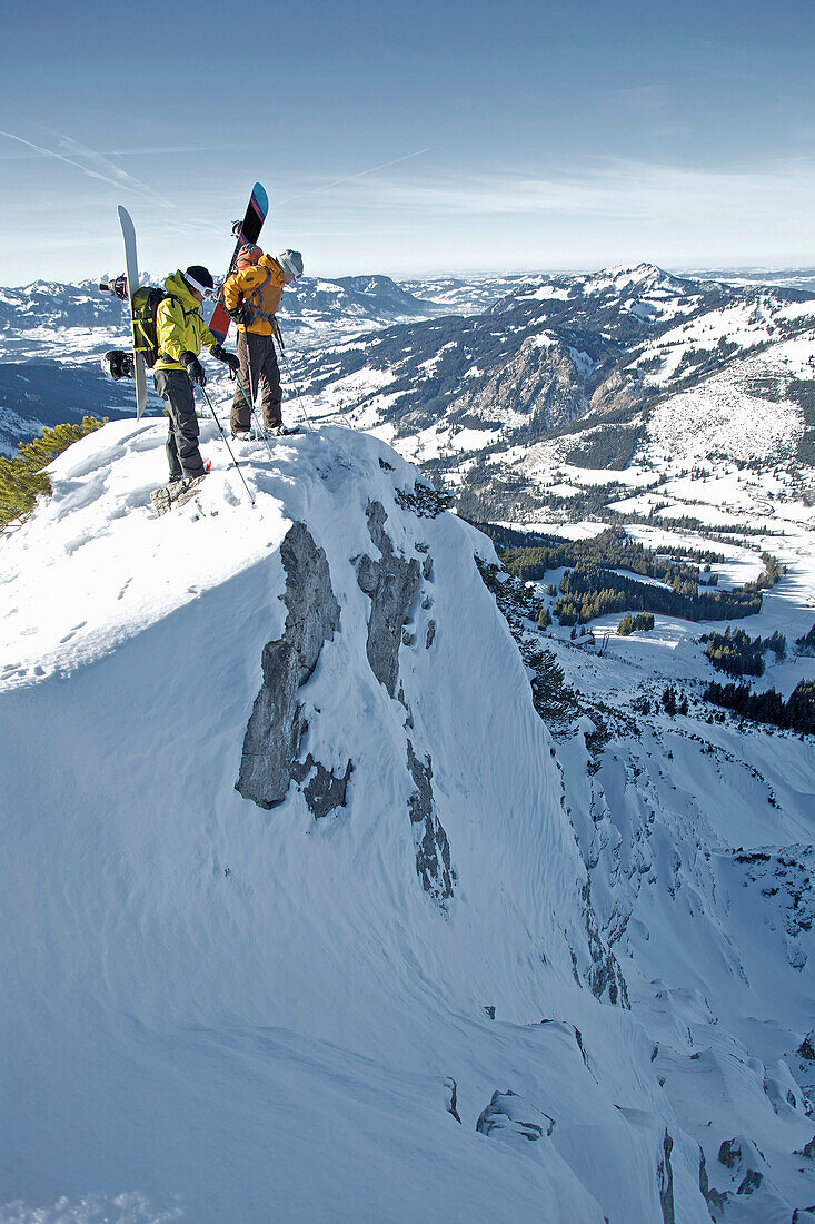 Two snowboarders standing on a mountain top, Oberjoch, Bad Hindelang, Bavaria, Germany