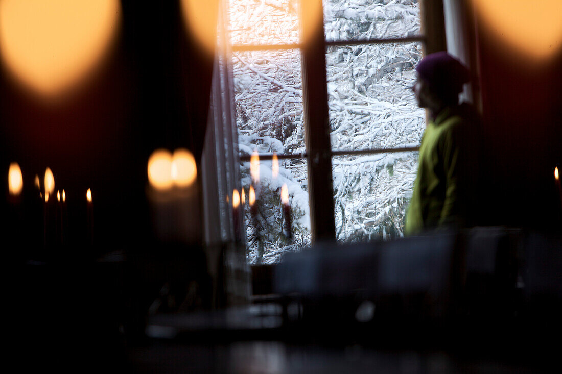 Mann sieht aus dem Fenster einer Herberge, Chandolin, Anniviers, Wallis, Schweiz