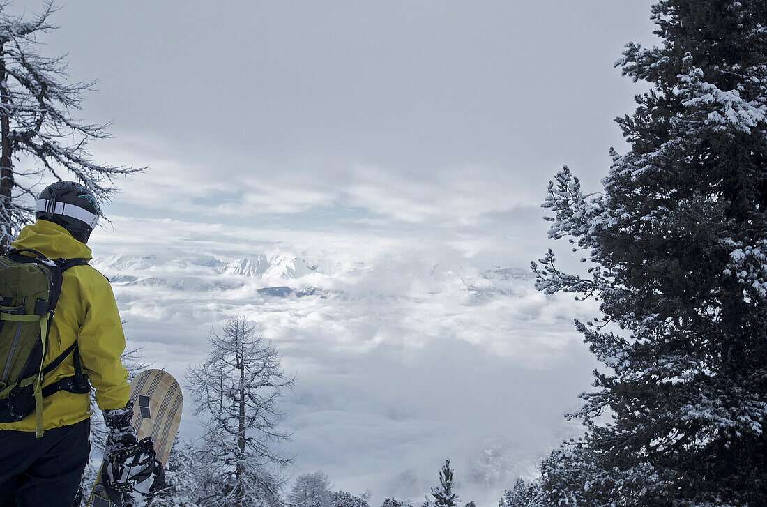 Snowboarder betrachet Bergpanorama, Chandolin, Anniviers, Wallis, Schweiz