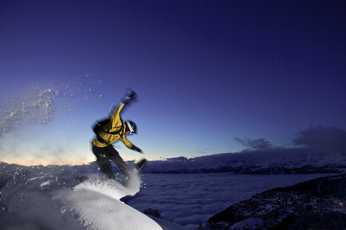 Snowboarder jumping at dusk, Chandolin, Anniviers, Valais, Switzerland