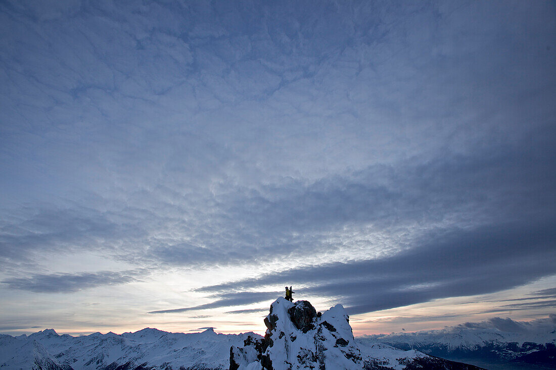 Snowboarder standing on a mountain in twilight, Chandolin, Anniviers, Valais, Switzerland