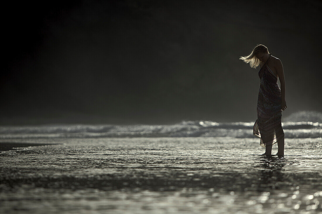 Junge Frau steht im flachen Wasser am Strand, Fuerteventura, Spanien