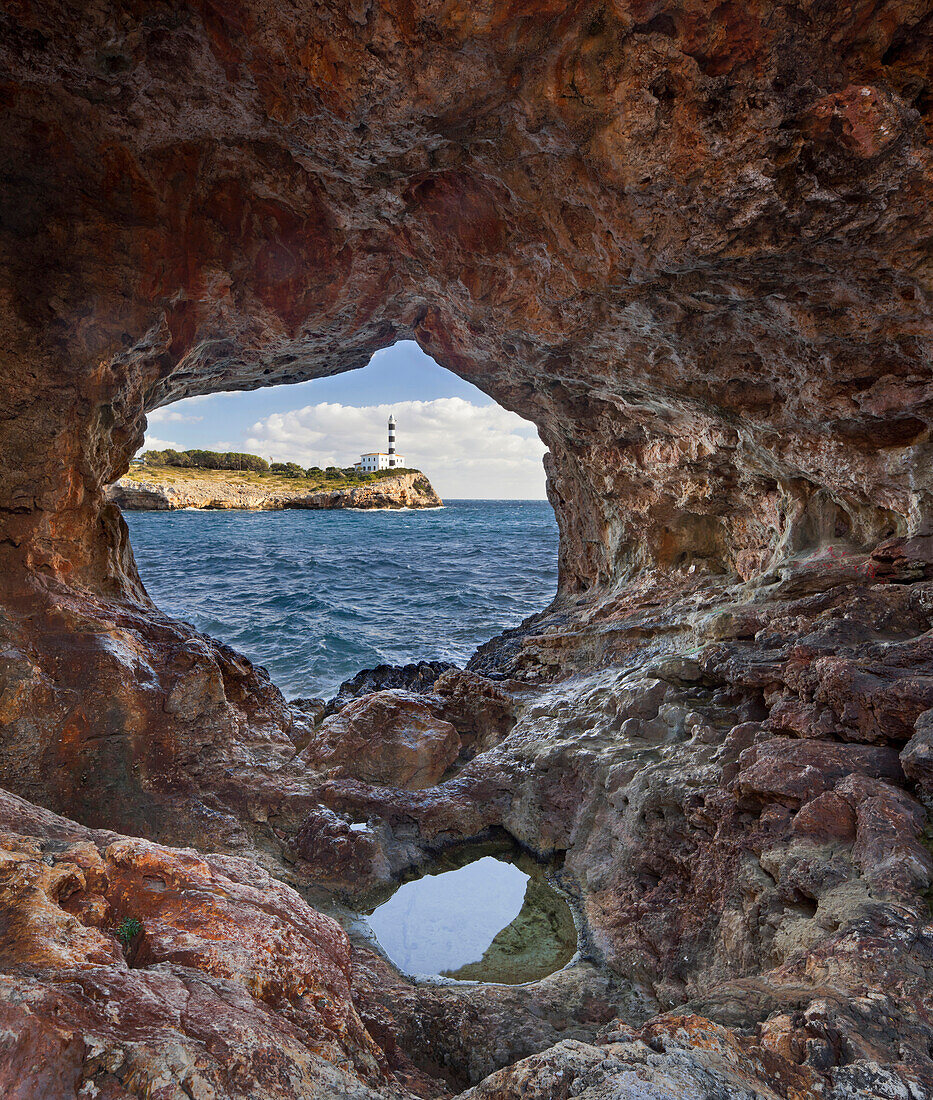 Blick durch ein Felsloch auf den Leuchtturm von Portocolom, Punta de s'Homonet, Ostküste, Mallorca, Spanien, Europa