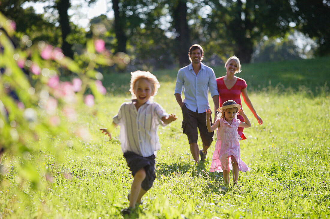 Familie läuft über Wiese, Starnberger See, Bayern, Deutschland