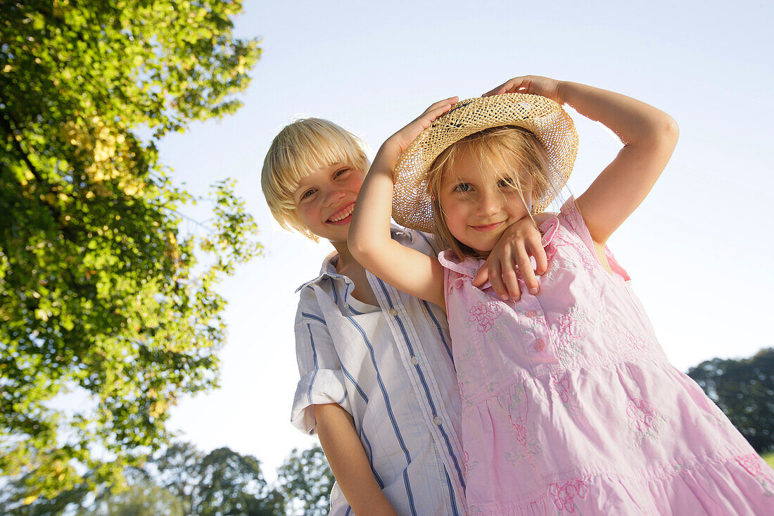 Sibling (5 and 7 years) smiling at camera, Lake Starnberg, Bavaria, Germany