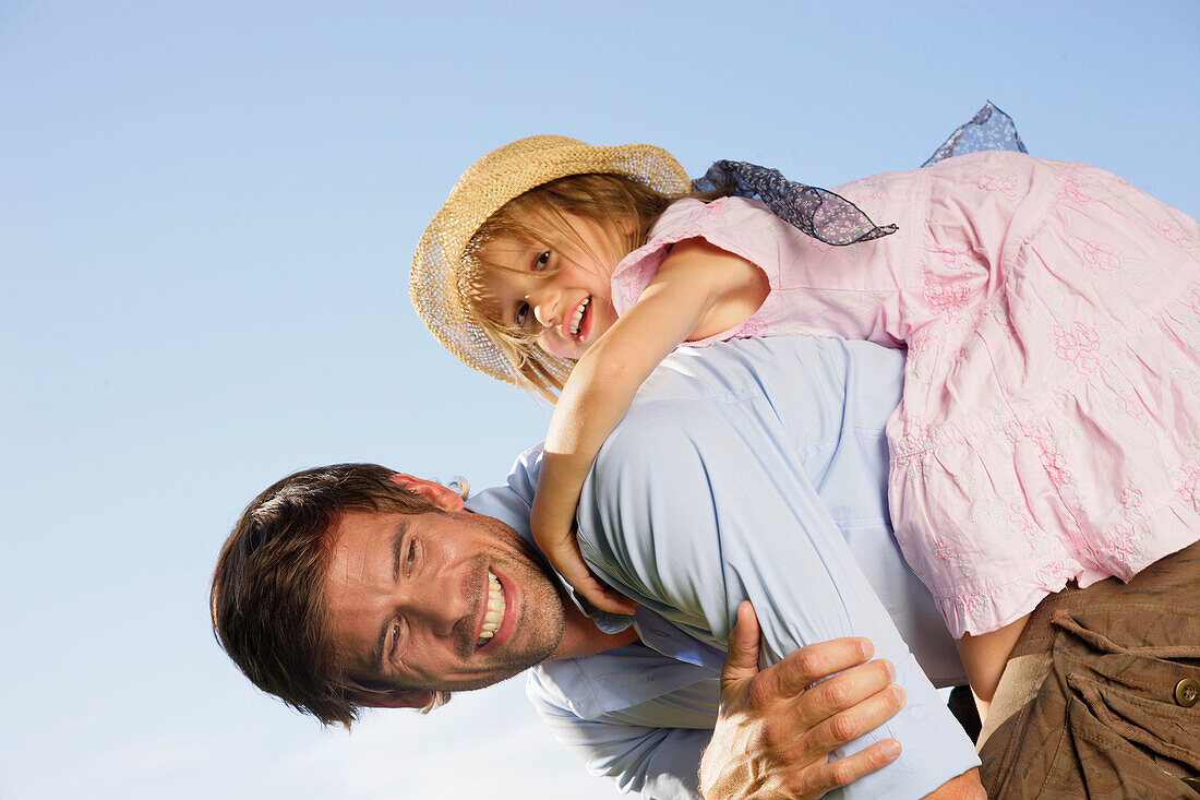 Father giving his daughter a piggyback ride, Lake Starnberg, Bavaria, Germany