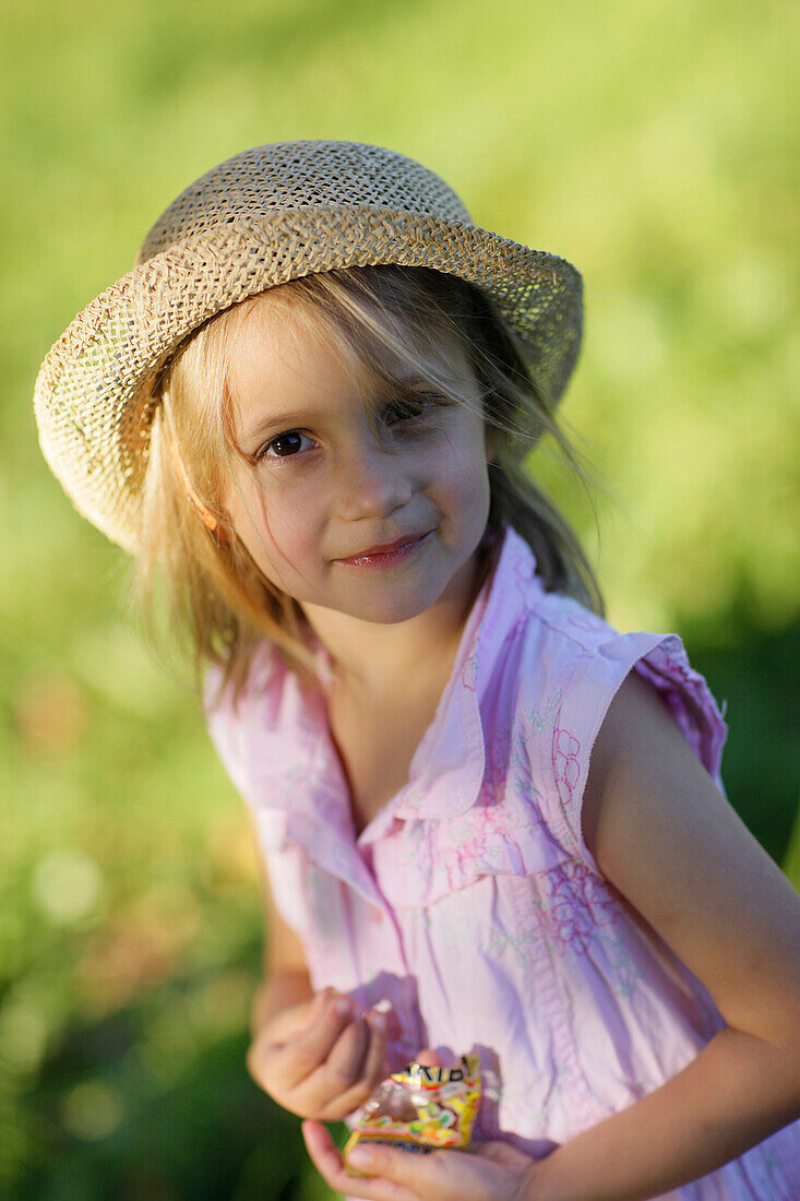 Mädchen (5 Jahre) nascht Gummibärchen, Starnberger See, Bayern, Deutschland