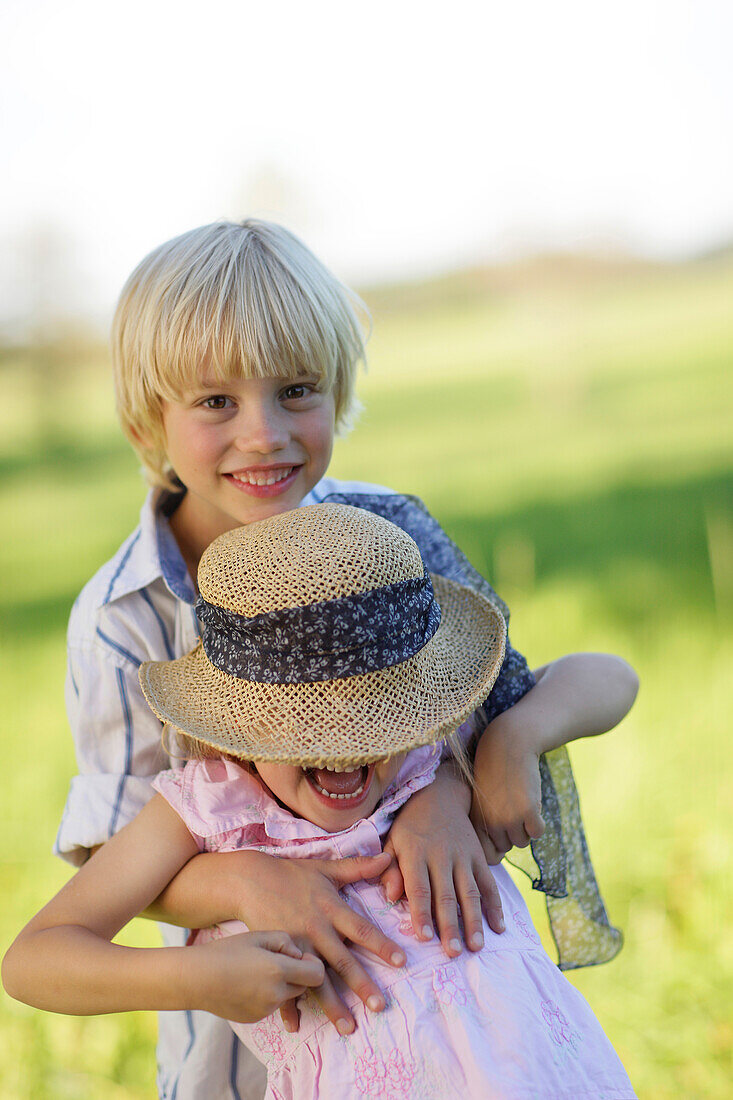 Sibling (5 and 7 years) playing on a meadow, Lake Starnberg, Bavaria, Germany