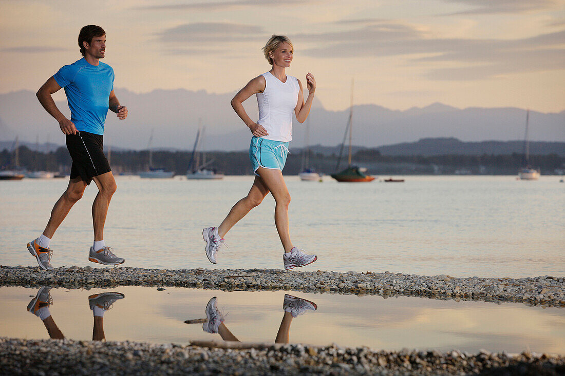 Paar joggt am Seeufer, Starnberger See, Bayern, Deutschland