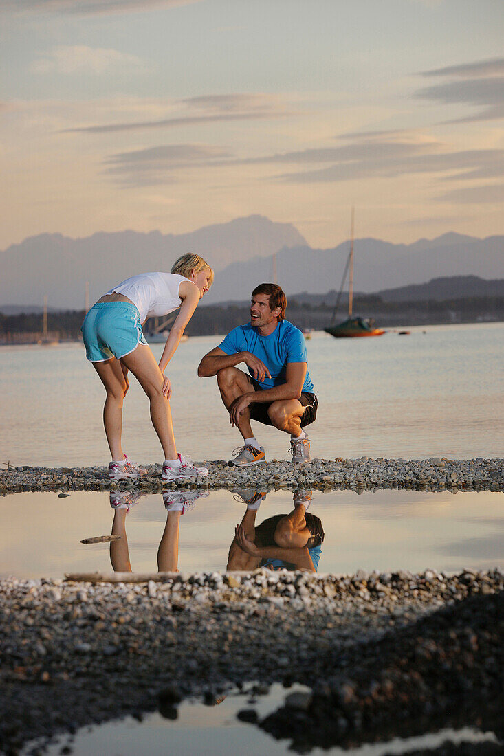 Couple wearing sports clothing at lake Starnberg, Bavaria, Germany