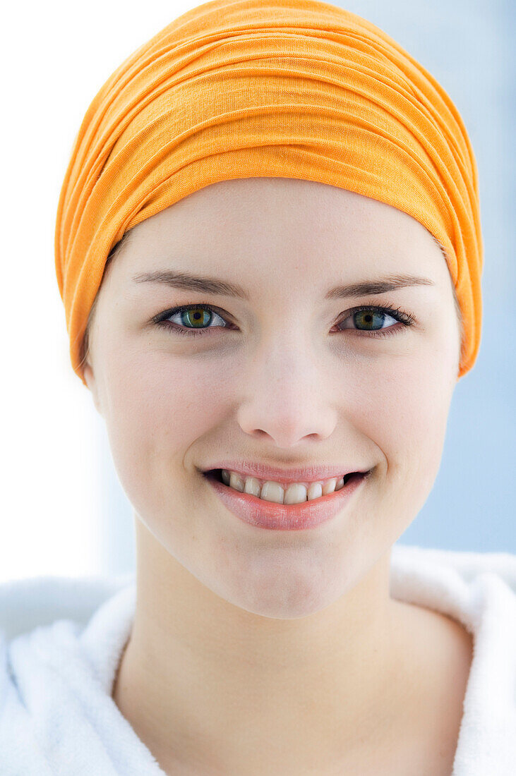Young Woman with headband looking at the camera, smiling, inside, close up