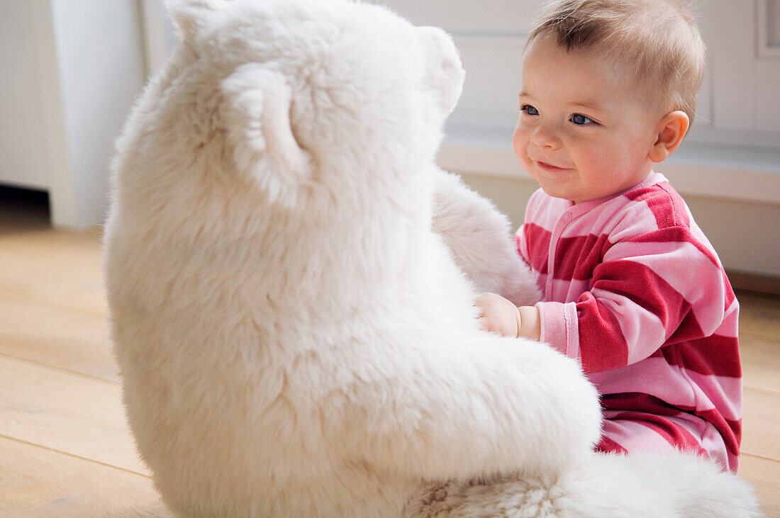 Baby playing with teddy bear