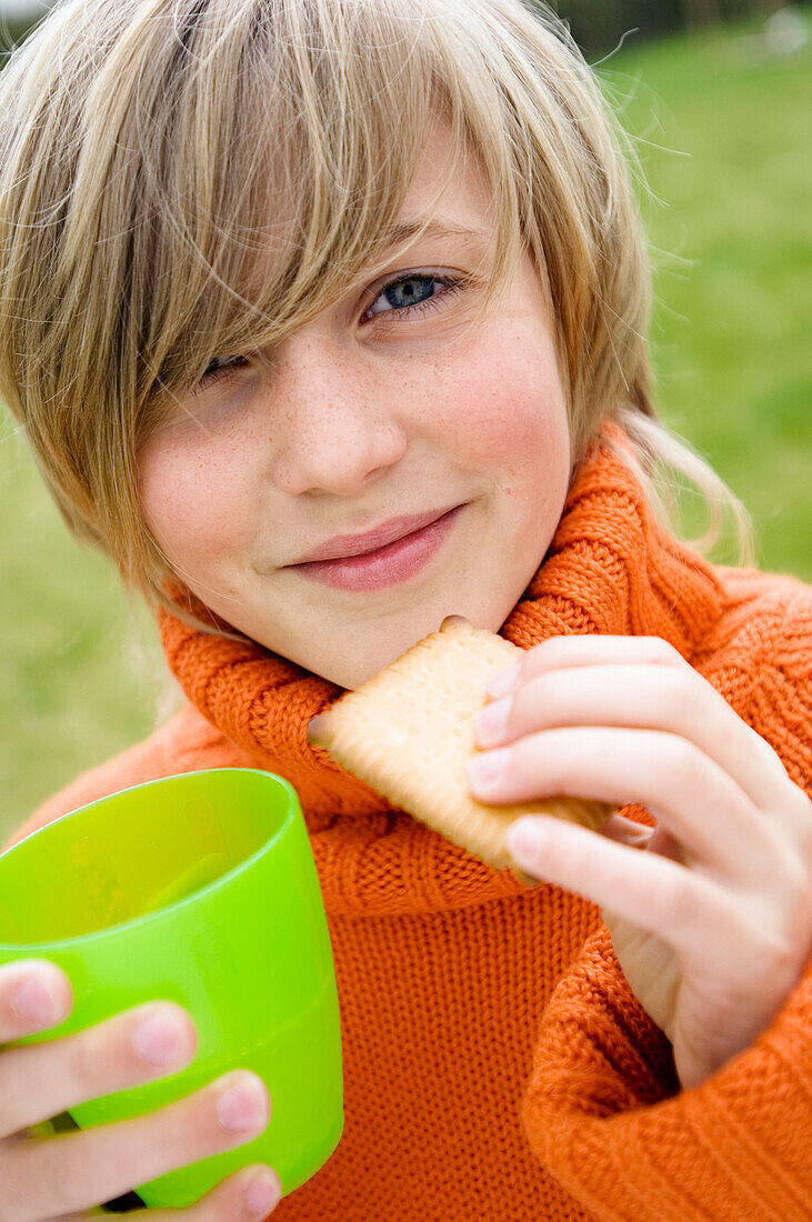 Portrait of a young boy with biscuit and glass