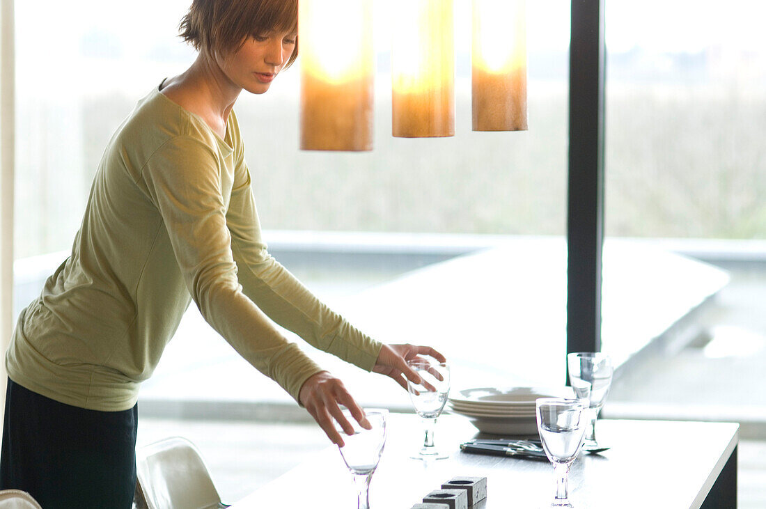 Young woman setting the table