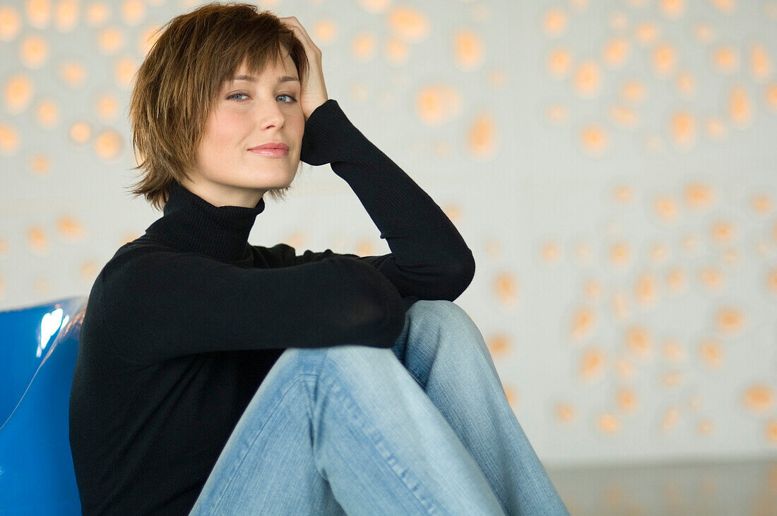 Young woman sitting on the floor, looking at the camera