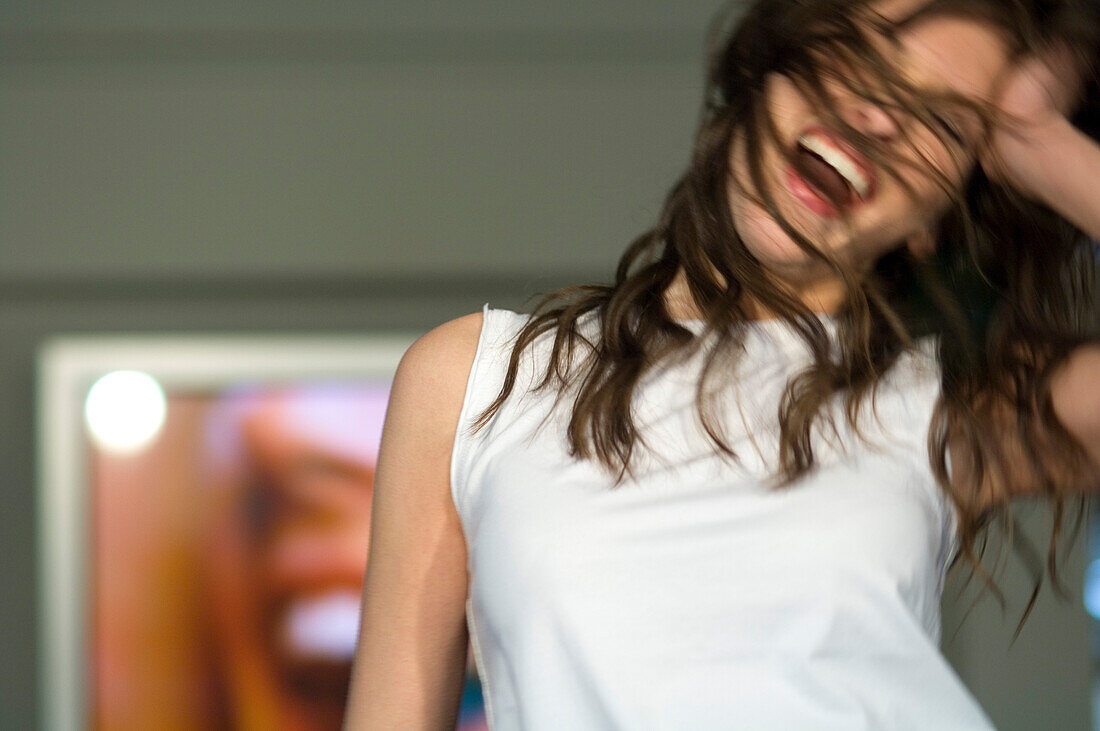 Young woman in white tank top, dancing, blurred motion
