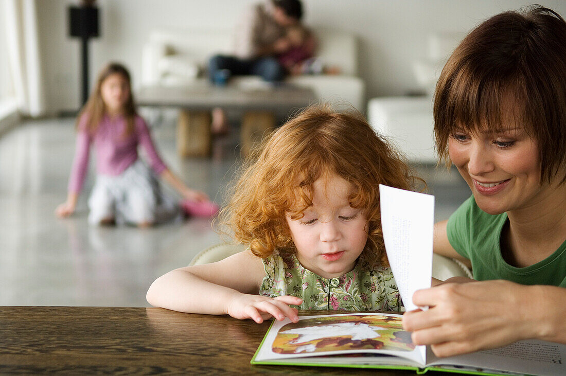 Woman and little girl reading a children's book