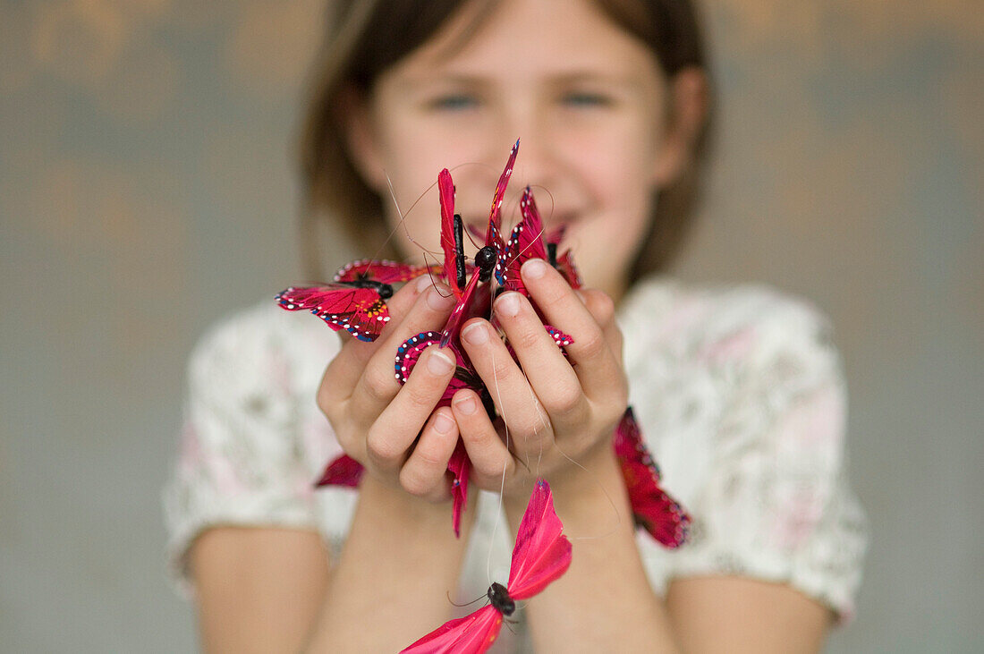Little girl holding butterfly garland, close-up