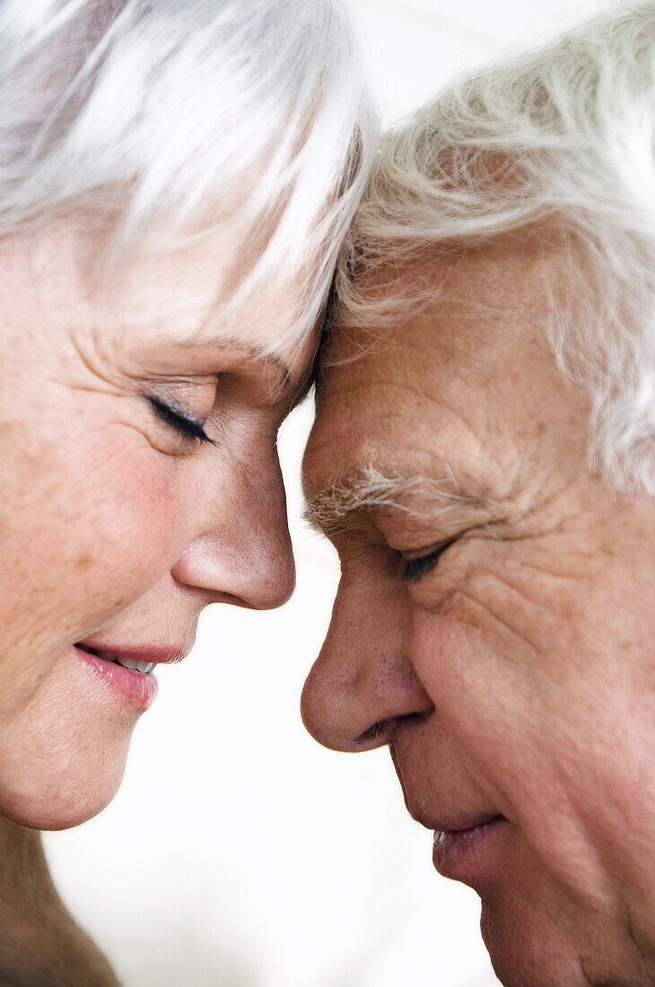 Senior couple face to face, eyes shut, close-up