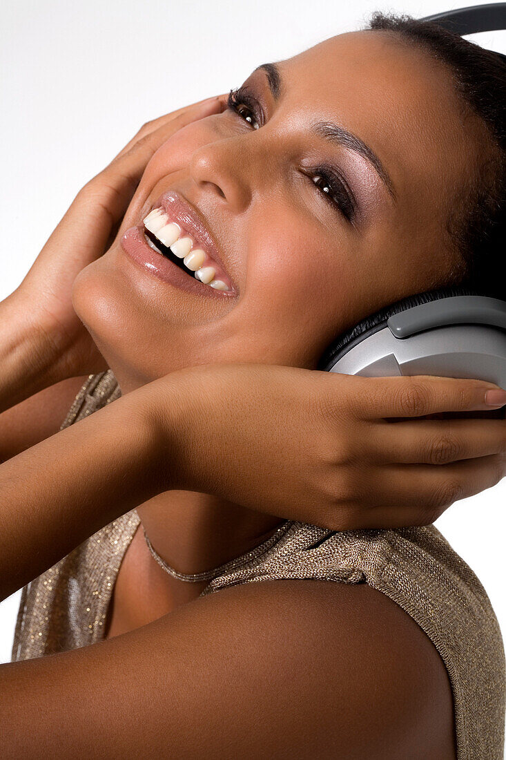 Portrait of a young smiling woman, listening to music with headphones