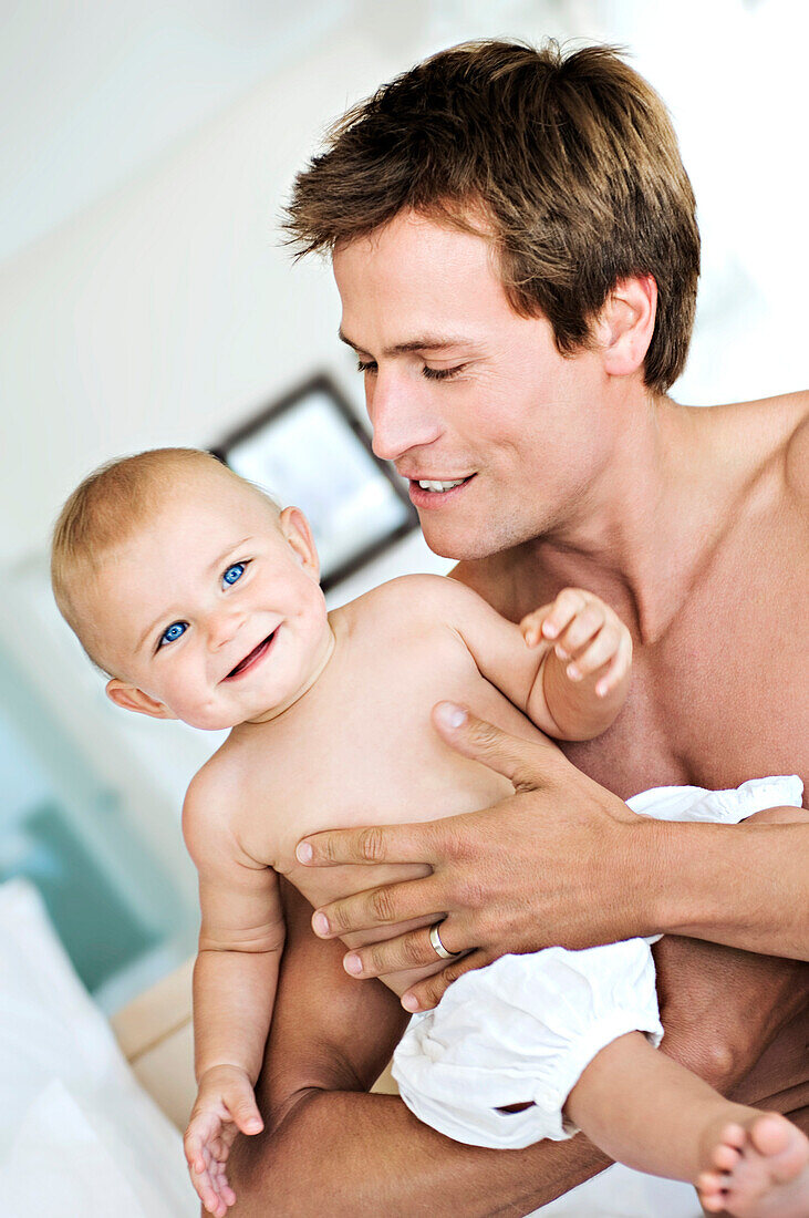 Father and his baby, smiling, indoors