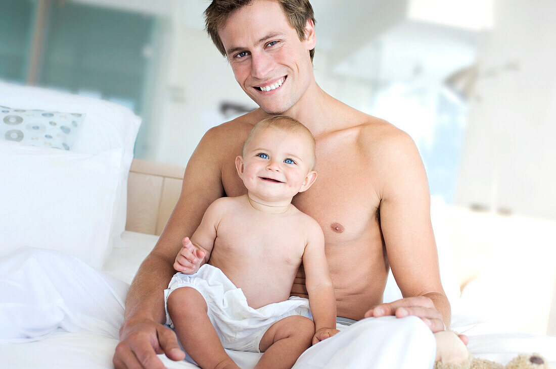 Father and baby smiling, indoors