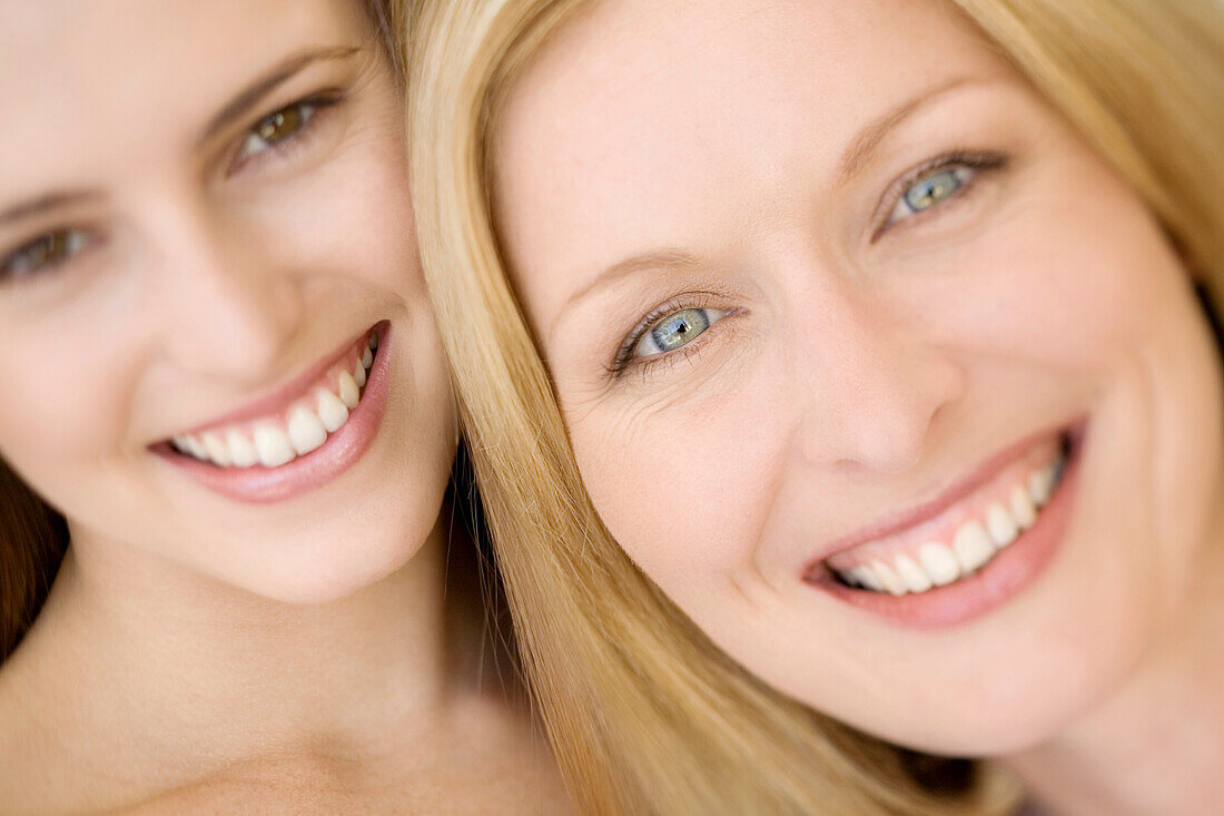 Portrait of two women smiling for the camera, indoors