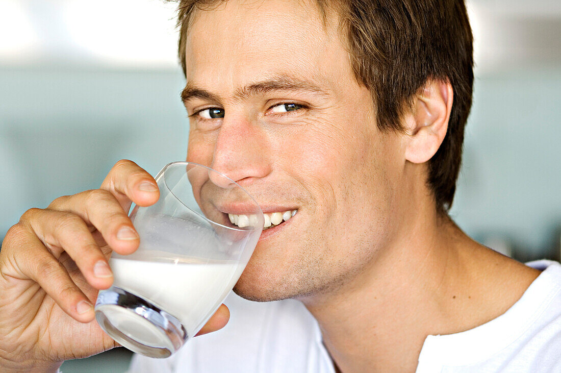 Portrait of a young man drnking glass of milk